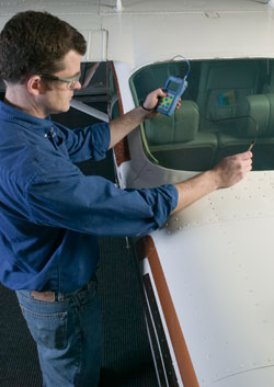 Inspector measure thickness of aircraft windsheild using a 35
