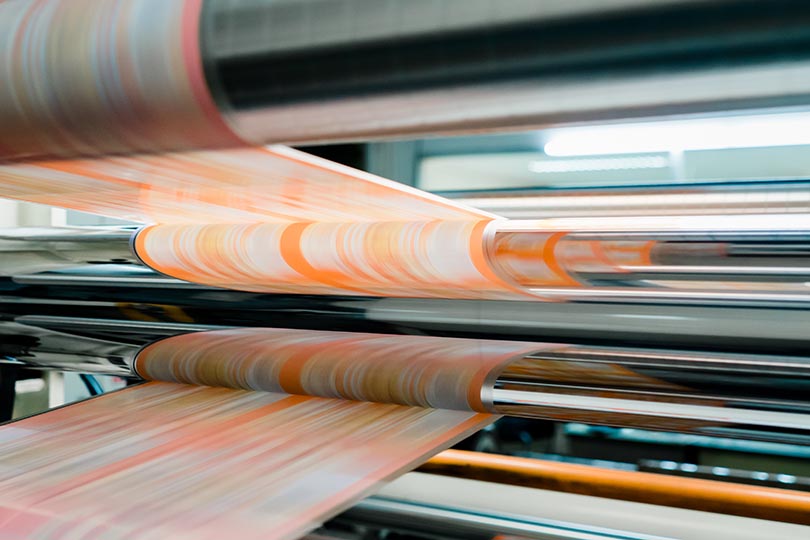轮转凹版印刷机正在使用凹版滚筒CYMK（印刷四分色模式）法印刷商品标签