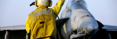 飞机控制员正在指挥F-18大黄蜂战斗机在航空母舰的飞行甲板上飞行
