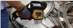 Olympus Innov-X DELTA handheld XRF alloy analyzer testing scrap stainless steel ribbons.