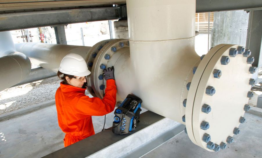 NDT inspector using an OmniScan X3 total focusing method and phased array flaw detector to perform an in-service inspection on pipes